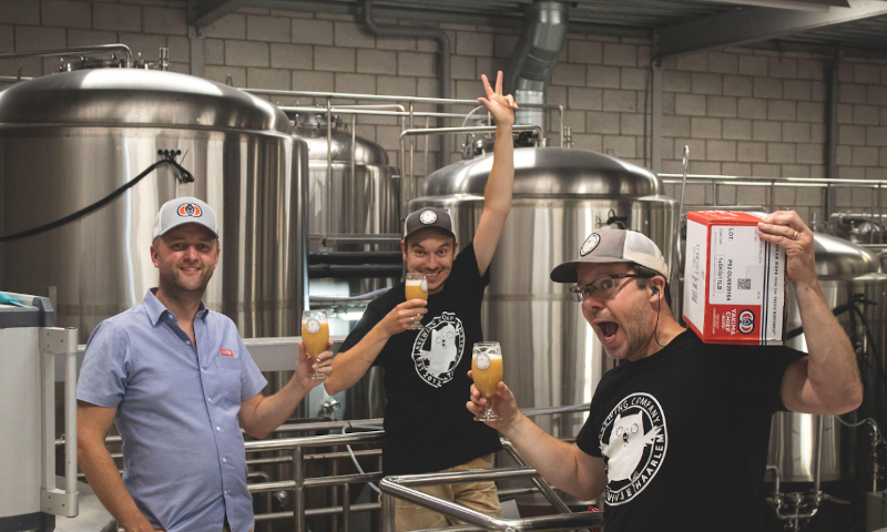 Drie vrolijke mannen van Yakima Chief Hops en het Uiltje  met een vers gebrouwen NEIPA in de hand 